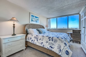 A bedroom with a bed, nightstands, a lamp, a window with a view, and a framed picture on the wall. - Our House at the Beach -east, 5th FL (Siesta Key)