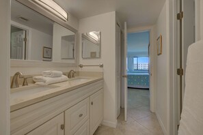 A bathroom with a double sink, a large mirror, and a towel rack. - Siesta Dunes on Siesta Key (Siesta Key)