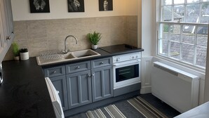 A kitchen with a sink, stove, and potted plants. - Remarkable 1-bed Apartment in Kirkby Lonsdale (Carnforth)