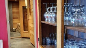 A wooden cabinet with multiple shelves filled with wine glasses.