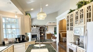 A spacious kitchen with a central island, wooden cabinets, a built-in oven, and a microwave. - Our Most Popular Lakefront Home (Carbondale)