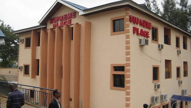 A building with 'SUPREME PLACE' signage, multiple windows, and air conditioning units. - Room-supreme Place Hotel - Guest Room (Abuja)