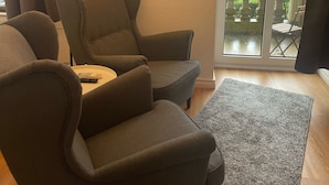 Un salon avec un canapé, une table basse et un tableau représentant une rue de la ville.