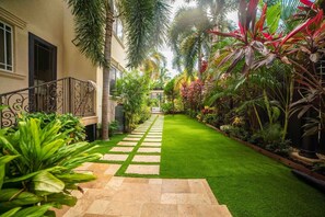 A well-maintained garden with a paved pathway leading to a building entrance.