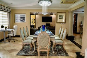 A conference room with a long table, chairs, a chandelier, and artwork on the walls.