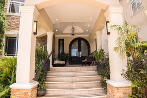 A multi-level entrance with a staircase, columns, and a door.