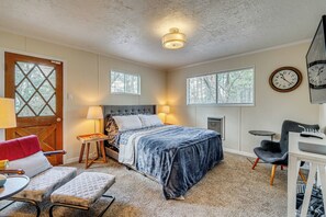 A bedroom with a bed, bedside tables, a chair, a desk, and a clock on the wall. - A-Frame Cabin w/ EV Charger, Arcade & Vinyl Lounge (Pioneer)