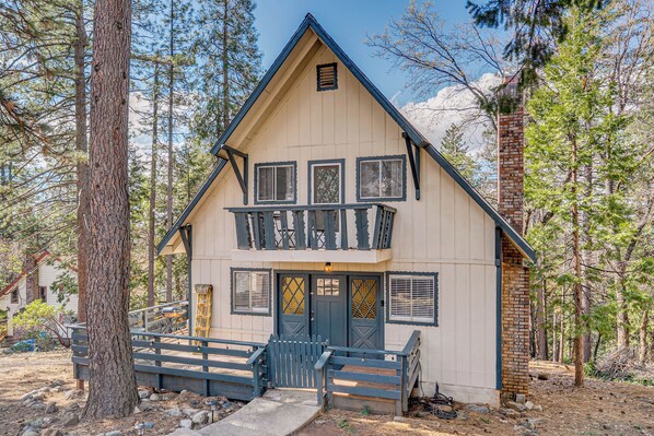 A two-story cabin with a balcony, surrounded by trees. - A-Frame Cabin w/ EV Charger, Arcade & Vinyl Lounge (Pioneer)