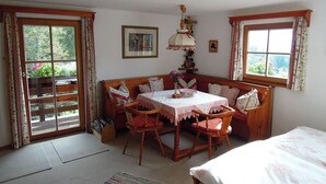 A cozy room with a wooden bench, a table with a tablecloth, and a bed.