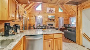 A wooden cabin interior with a kitchen, dining area, and living room. - Pigeon Forge | Hot Tub & Arcade (Pigeon Forge)