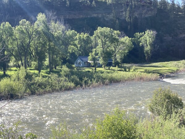 A riverside view with a house surrounded by trees and grassy areas. - Magical Riverside Retreat on 450 Private Acres (Pagosa Springs)