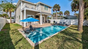 A two-story house with a swimming pool, a covered patio, and a white fence. - Heated Pool + Games | Golf Cart | Near Beach (Jacksonville Beach)