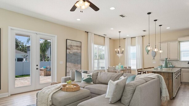 A spacious living room with a sectional sofa, a dining area, and a kitchen. - Heated Pool + Games | Golf Cart | Near Beach (Jacksonville Beach)