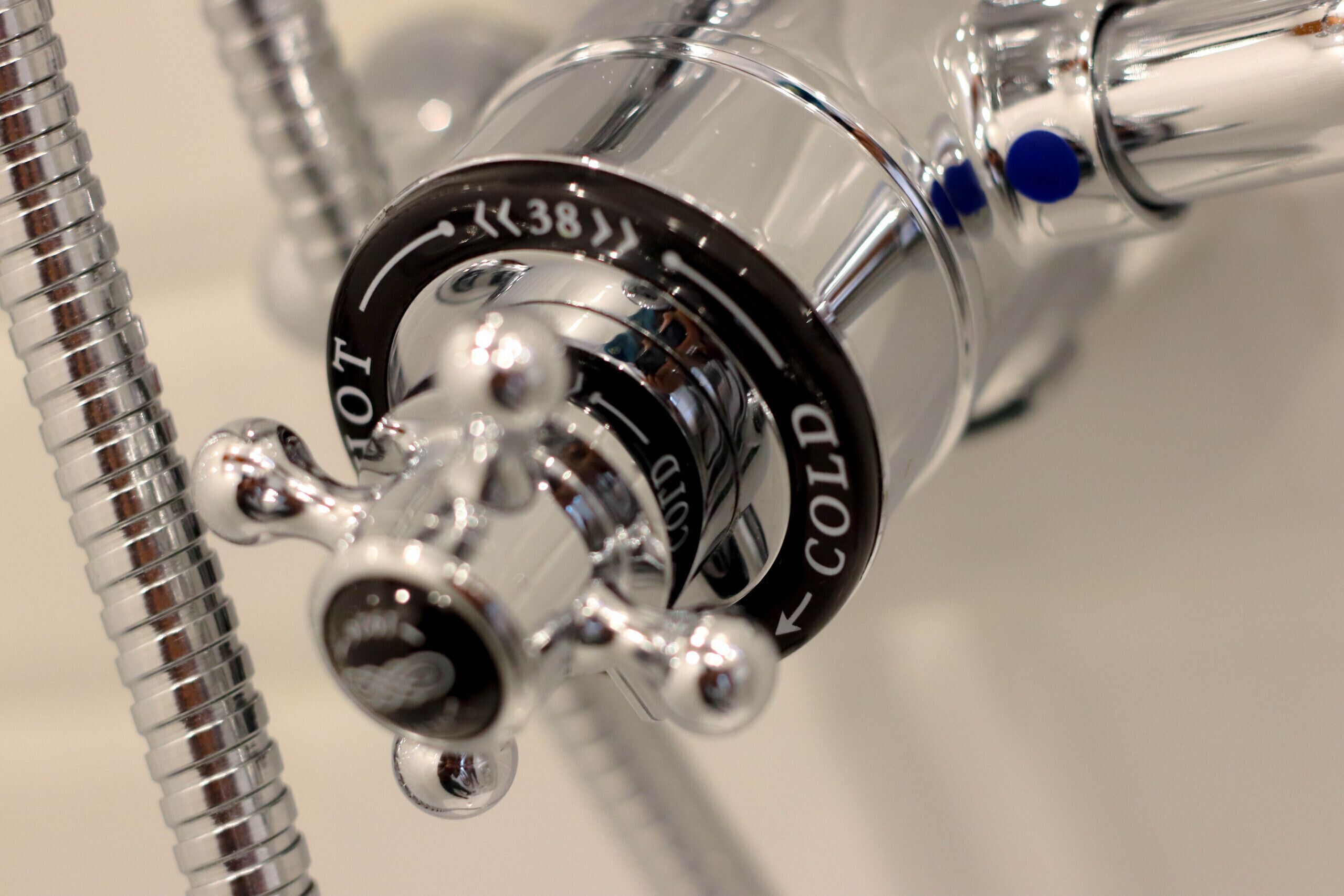 A close-up of a metallic, transparent object with inscriptions "COLD" and "HOT" indicating temperature settings.