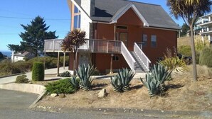 A two-story house with a balcony, a staircase, and a driveway.