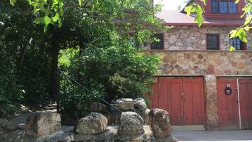 A stone building with a red roof and a stone wall with rocks.