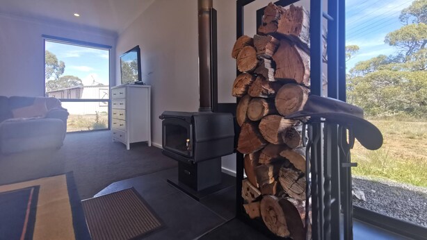 A modern living room with a fireplace, a sofa, and a television. - A Yingina Getaway, Home of Brown Trout (Miena)