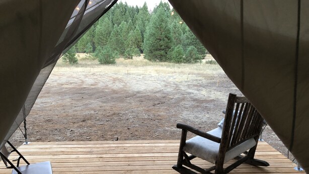 A tent with a wooden deck, a rocking chair, and a folding chair. - Glamping #4, Nature Immersion, River access, Butterfly Pavilion (Cave Junction)