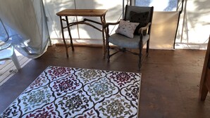 A room with a wooden chair, a small table, and a patterned rug. - Glamping #4, Nature Immersion, River access, Butterfly Pavilion (Cave Junction)
