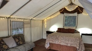 A tented room with a bed, a sofa, and a rug. - Glamping #4, Nature Immersion, River access, Butterfly Pavilion (Cave Junction)