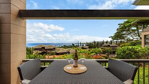 A balcony with a table, two wine glasses, and a bottle. - Ridge 1712- Ocean View w/Platinum Interiors! (Lahaina)