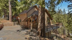 A cabin with a porch, surrounded by tall trees. - Preferred Parking Pass to Dodge Ridge (Cold Springs)