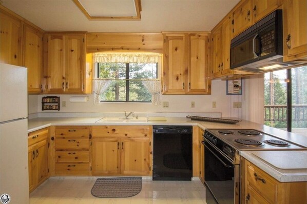 Kitchen features a window with an outdoor view, microwave, and stove with four burners.