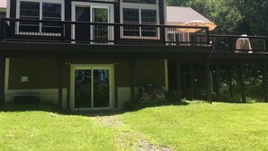 A two-story house with a balcony, a covered porch, and a large sliding glass door.