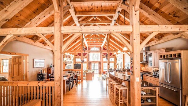 A spacious kitchen with wooden beams, a bar area, and a dining space.