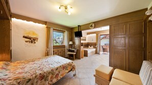 A bedroom with a bed, a desk, a chair, a sofa, and a television. - Apartment "Residence Lastè Catinaccio" with Mountain View, Wi-Fi, Garden & Balcony (Moena)