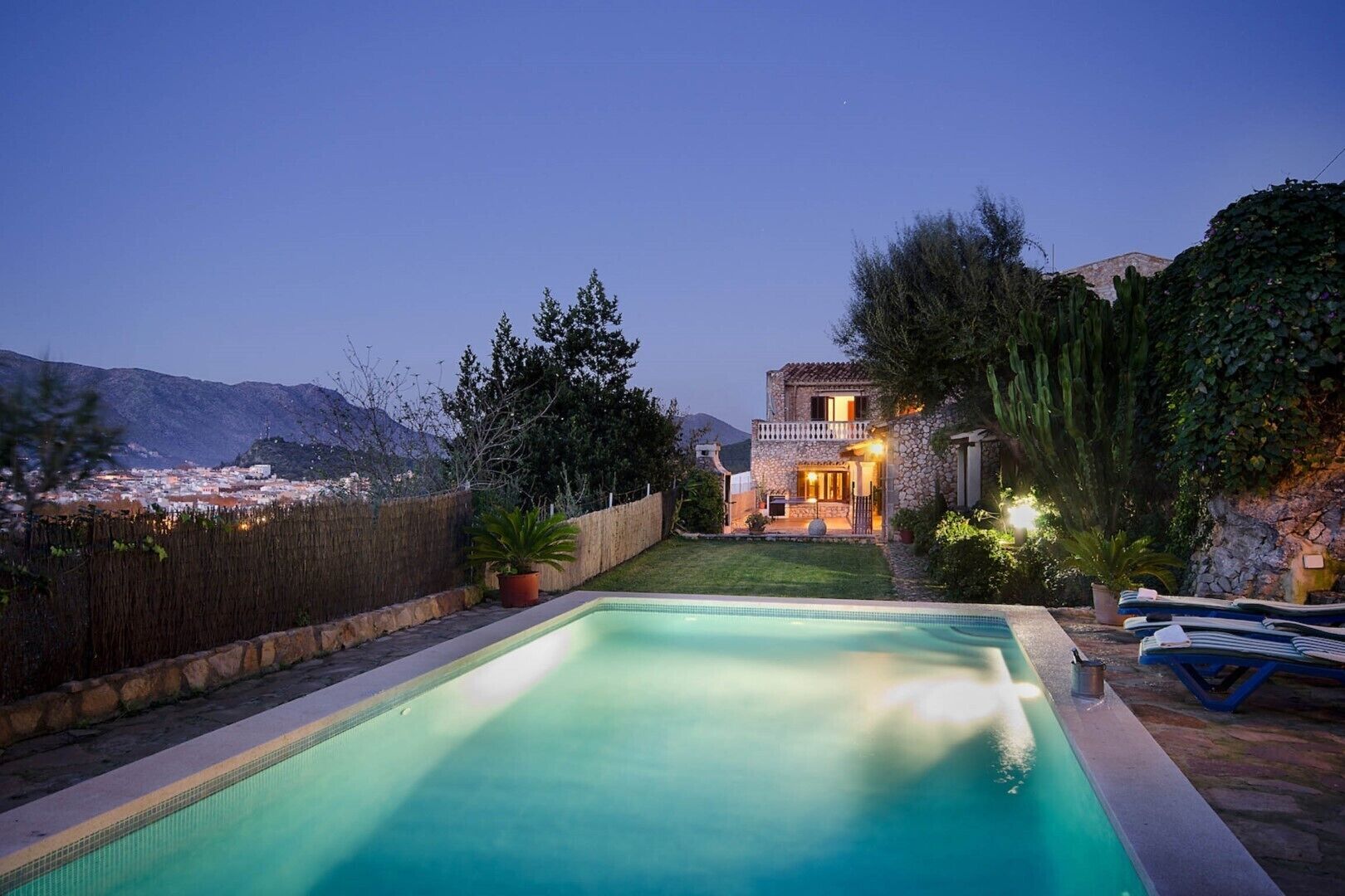 A swimming pool with a view of a cityscape and mountains in the background.