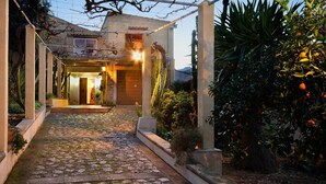 A cobblestone pathway leading to a house with a covered entrance, surrounded by greenery and a cactus. - Holiday Home 'Can Moragues' with Mountain View, Wi-Fi and Air Conditioning (Pollensa)