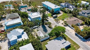 Zona residencial costera con casas, piscina y playa al fondo.