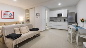 A modern apartment with a kitchenette, a dining area, and a living room with a sofa. - Apartment Navigator (Dubrovnik)