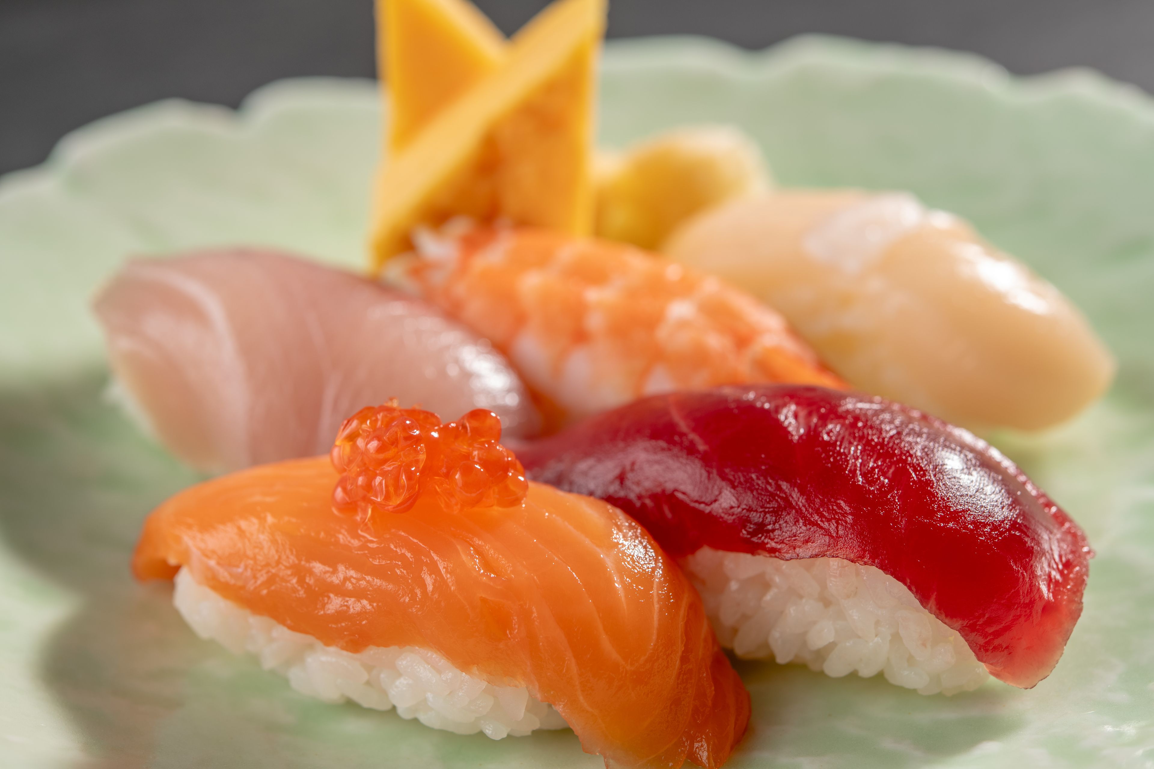 A plate of sushi with various types of fish and toppings.