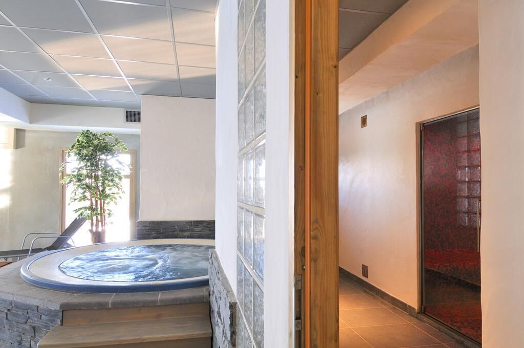 A spa area with a hot tub, a staircase, and a potted plant.