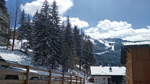 A snow-covered mountain village with wooden buildings and a stone wall. - Cozy Apartment in Châtel, 6 Pers. (Châtel)