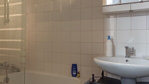 Ein Badezimmer mit Badewanne, Waschbecken und Spiegel.