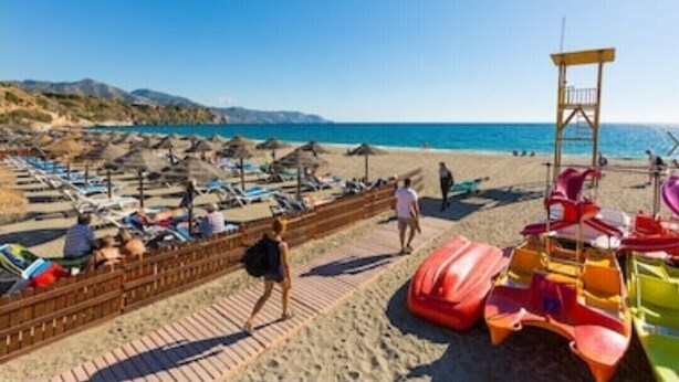 A beach with sun loungers, umbrellas, and a lifeguard tower. - VILLA MIJAS PLAYA (AN)