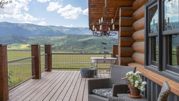 A wooden deck with wicker furniture, a bathtub, and a view of mountains. - Aspen Bear Paws | Charming Retreat with Hot Tub & Loft (Alpine)