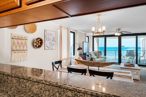 Enjoy ocean views from the spacious seating area, featuring a sofa, chairs, and large windows.