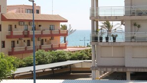 A multi-story building with balconies overlooking a coastal area. - Argenta Caleta Apartaments (Peniscola)