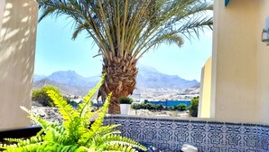 A balcony with a potted plant, a woven basket, and a patterned wall. - Mareverde spacious 1 bedroom apartment (Costa Adeje)