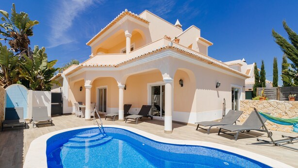 A two-story house with a swimming pool, outdoor seating, and a stone wall. - Poolvilla Casa Vista Mar (Carvoeiro)