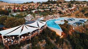 A resort with multiple bungalow-style buildings, a swimming pool, and a covered dining area. - Arameras Resort (Ksamil)