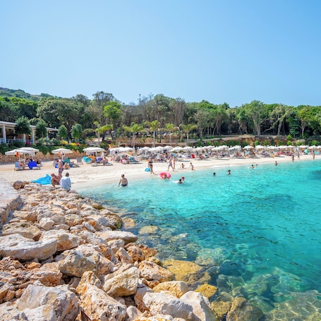 On the beach, white sand, beach umbrellas, beach bar. Arameras Resort
