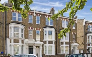 A row of terraced houses with bay windows and a brick facade. - Portobello Stays by Stay Guru (London)