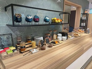 Un bufé de desayuno con diversos alimentos y acompañamientos.