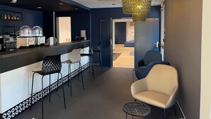A modern bar area with a counter, seating, and a decorative hanging light fixture. - Kyriad Direct  - Bourg les Valence (Bourg-les-Valence)