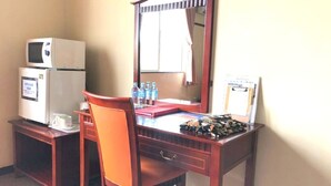 A hotel room with a wooden desk, a chair, a microwave, a refrigerator, a mirror, and a window with a curtain. - Hotel Robinson INN Ryukyu Tabikan MW1 (Okinawa)